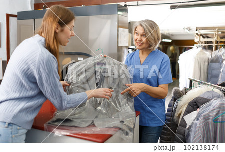 Fine worker giving woman her clean clothes 102138174