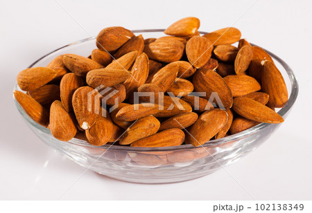 Image of roasted salt almonds on glass bowl, nobody 102138349