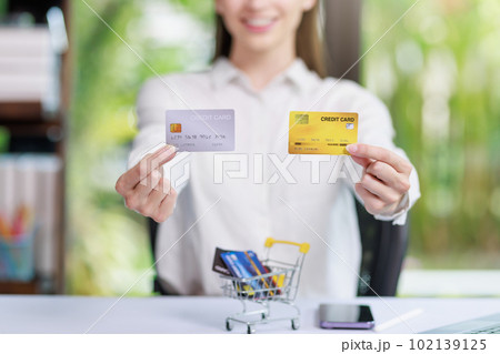 Concept of Online shopping, e-commerce, Woman holding credit card and using laptop computer for shopping online,Businesswoman paying for goods or services using credit card through online channels 102139125