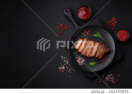 Delicious juicy pork steak on the bone with spices and herbs 102143635