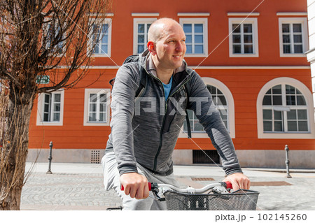 Portrait of a handsome hipster man. A man in a big city cycling down the street on a bicycle, a life style concept Portrait of a handsome hipster man. A man in a big city cycling down the street on a bicycle, a life style concept 102145260