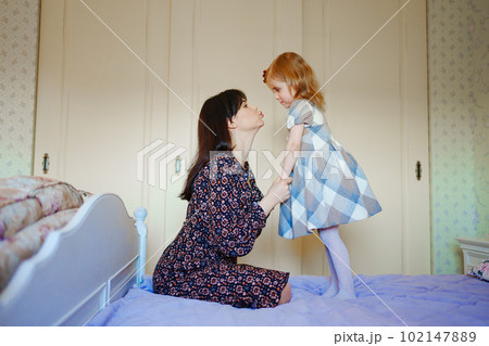 mother and daughter play and have fun on the bed.  102147889
