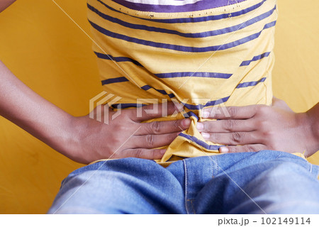 boy suffering stomach pain sitting on chair boy suffering stomach pain sitting on chair 102149114