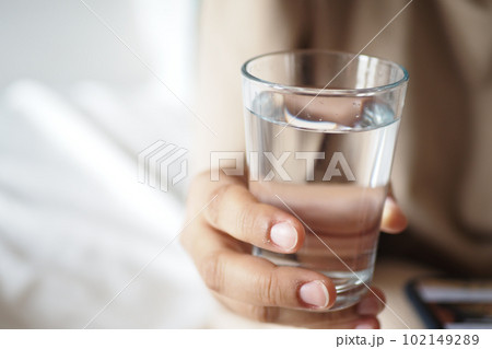 holding a glass of water with copy space  102149289