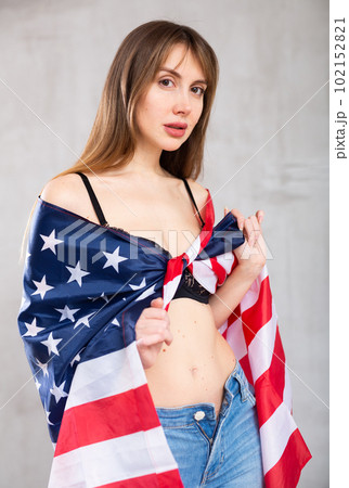 Young pretty woman proudly displaying flag of usa 102152821