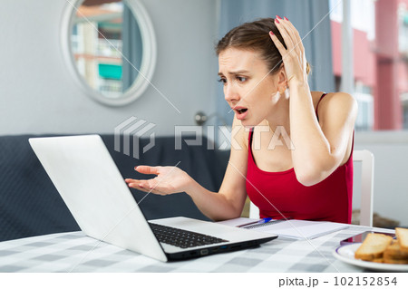 Disappointed woman with laptop at home 102152854