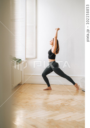Young slim woman in sportwear doing fitness exercises, girl dancing at bright studio Young slim woman in sportwear doing fitness exercises, girl dancing at bright studio 102158853