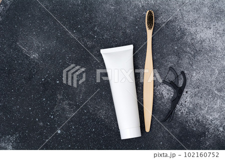 Oral care products. Toothbrush, paste and floss on a black background. Healthy smile concept. 102160752