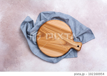 Wooden cutting board on a light background. Kitchenware top view. Empty space for your ready meals. Wooden cutting board on a light background. Kitchenware top view. Empty space for your ready meals. 102160954