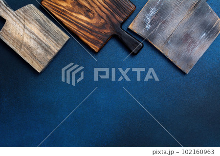 Set of old stylish wooden cutting board on a blue background. Kitchenware top view. Empty space for your ready meals. Set of old stylish wooden cutting board on a blue background. Kitchenware top view. Empty space for your ready meals. 102160963