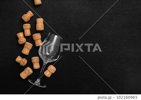 Glass empty glass and wine corks . on a black background Glass empty glass and wine corks . on a black background 102160965
