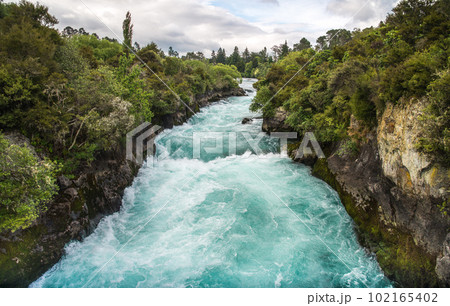 The upstream of Huka falls an iconic tourist most natural attraction place in Taupo, New Zealand. View from pedestrian bridge. The upstream of Huka falls an iconic tourist most natural attraction place in Taupo, New Zealand. View from pedestrian bridge. 102165402
