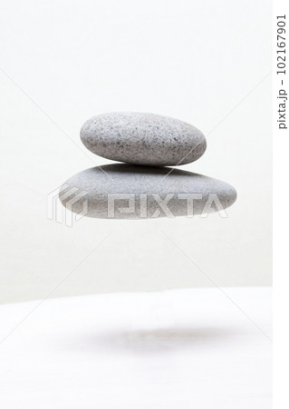白い背景で合成加工撮影した宙に浮く丸い石  102167901