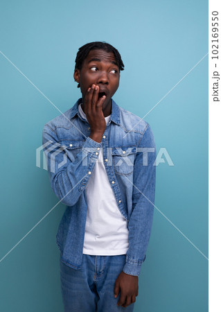 close-up portrait of a surprised young african guy with dreadlocks in a denim jacket close-up portrait of a surprised young african guy with dreadlocks in a denim jacket 102169550