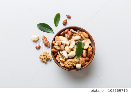 mixed nuts in bowl. Mix of various nuts on colored background. pistachios, cashews, walnuts, hazelnuts, peanuts and brazil nuts mixed nuts in bowl. Mix of various nuts on colored background. pistachios, cashews, walnuts, hazelnuts, peanuts and brazil nuts 102169716