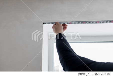 repairman holding tape measure. 102173350
