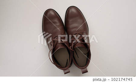 cleaning brown leather boots on white background 102174745