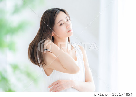リビングで花束を持つ若い女性 102174854