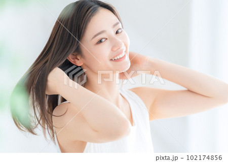 リビングで花束を持つ若い女性 102174856