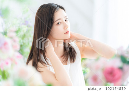 花に囲まれてスキンケアをする若い女性 102174859
