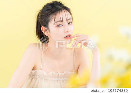 イエローバックでスキンケアをする若い女性 イエローバックでスキンケアをする若い女性 102174889