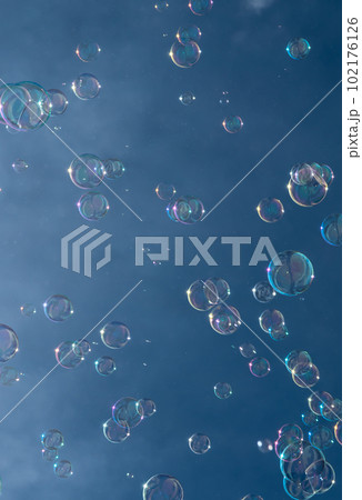 Numerous Colorful Soap Bubbles Float In Mid-Air In Front Of Blue Sky 102176126