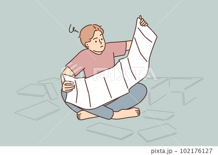 Man reads instructions for assembling furniture sitting on floor among spare parts from wardrobe 102176127