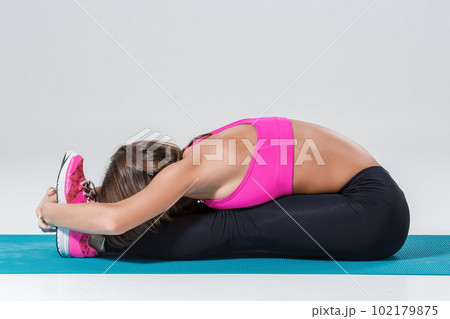Sporty flexible girl doing stretching exercise 102179875