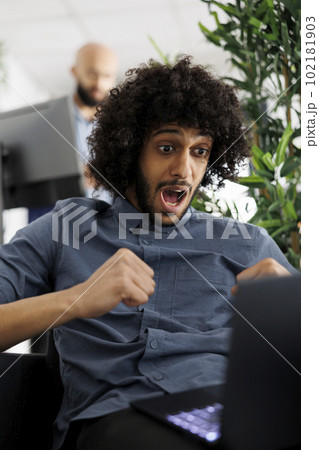 Arab company entrepreneur celebrating winning project contract while working on laptop in business office. Executive manager happy about achieving kpi, showing triumph gesture Arab company entrepreneur celebrating winning project contract while working on laptop in business office. Executive manager happy about achieving kpi, showing triumph gesture 102181903