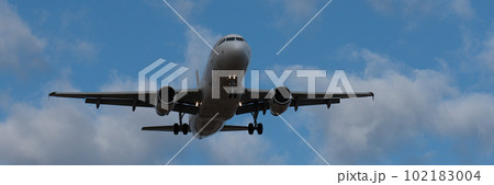 Landscape with white passenger airplane is flying in the blue sky with clouds at overcast day. Landing airplane. Travel background. Passenger airliner. Business trip. Commercial aircraft Landscape with white passenger airplane is flying in the blue sky with clouds at overcast day. Landing airplane. Travel background. Passenger airliner. Business trip. Commercial aircraft 102183004