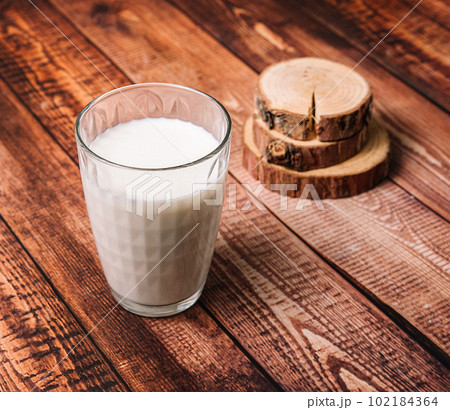 Large glass of milk on an old wooden table, dairy products, stock photo. Large glass of milk on an old wooden table, dairy products, stock photo. 102184364