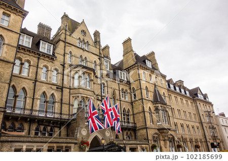 英国国旗が飾られた歴史的なレンガ造りの大きな建物　オックスフォードの街並み 102185699