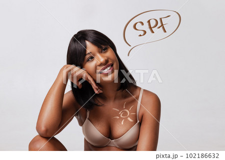 Portrait of beautiful, smiling, young, african woman in underwear, with well-kept healthy skin. SPF face care, sunscreen importance 102186632
