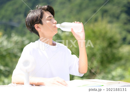 屋外で水分補給をする若い男性 屋外で水分補給をする若い男性 102188131