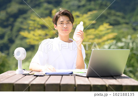 屋外で水分補給をする若い男性 屋外で水分補給をする若い男性 102188135