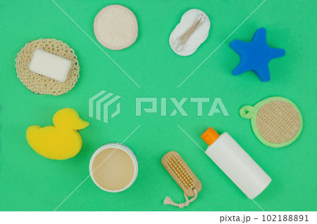 Washcloths, shampoo and other accessories in green background. Copy space. Top view. 102188891