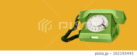 Retro rotary green phone with cord on orange ad banner background with copy space for text 102193443