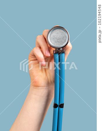 Hand holding stethoscope on blue background, to you me 102194548
