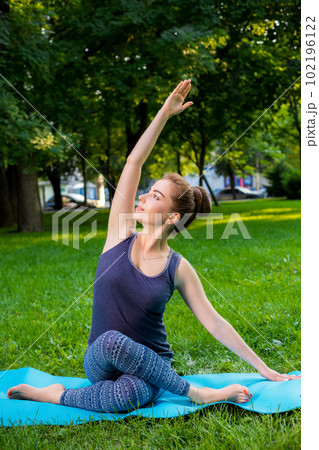 Young woman doing yoga exercises in the summer city park. Young woman doing yoga exercises in the summer city park. 102196122