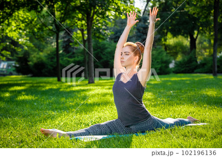 Young woman doing yoga exercises in the summer city park. Young woman doing yoga exercises in the summer city park. 102196136