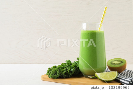 Tasty fresh kale smoothie on white wooden table. Space for text Tasty fresh kale smoothie on white wooden table. Space for text 102199963
