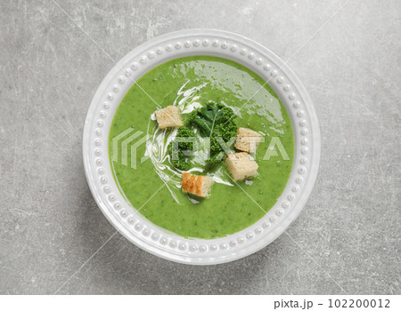 Tasty kale soup with croutons on grey table, top view 102200012