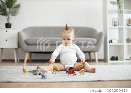Infant child staying calm and happy while playing at home 102200416