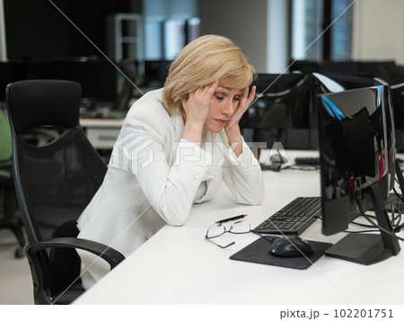 Tired caucasian woman at her desk in the office. Tired caucasian woman at her desk in the office. 102201751