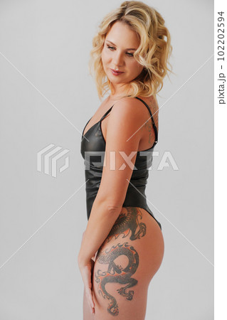 a sexy blonde with tattoos in a leather swimsuit a sexy blonde with tattoos in a leather swimsuit 102202594