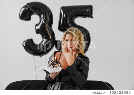 woman sexily eats the cake with candles number thirty-five woman sexily eats the cake with candles number thirty-five 102202609
