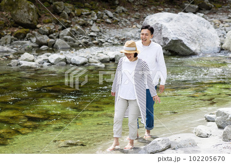 河原で水遊びを楽しむカップル 102205670