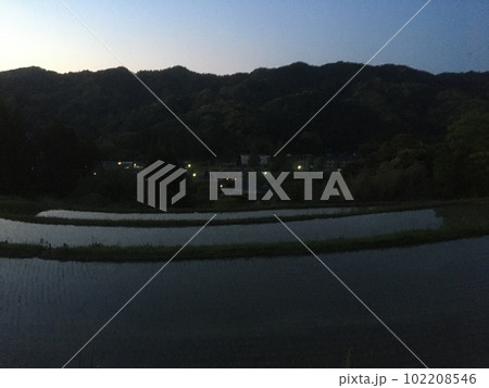 あけぼのの田植えを終えたばかりの大山千枚田と谷間の家々の灯り 102208546