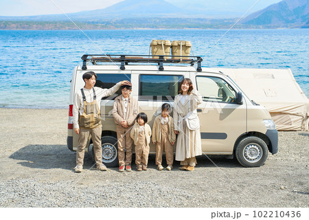 アウトドアを楽しむ家族とキャンピングカー 102210436