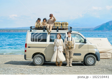 アウトドアを楽しむ家族とキャンピングカー 102210441